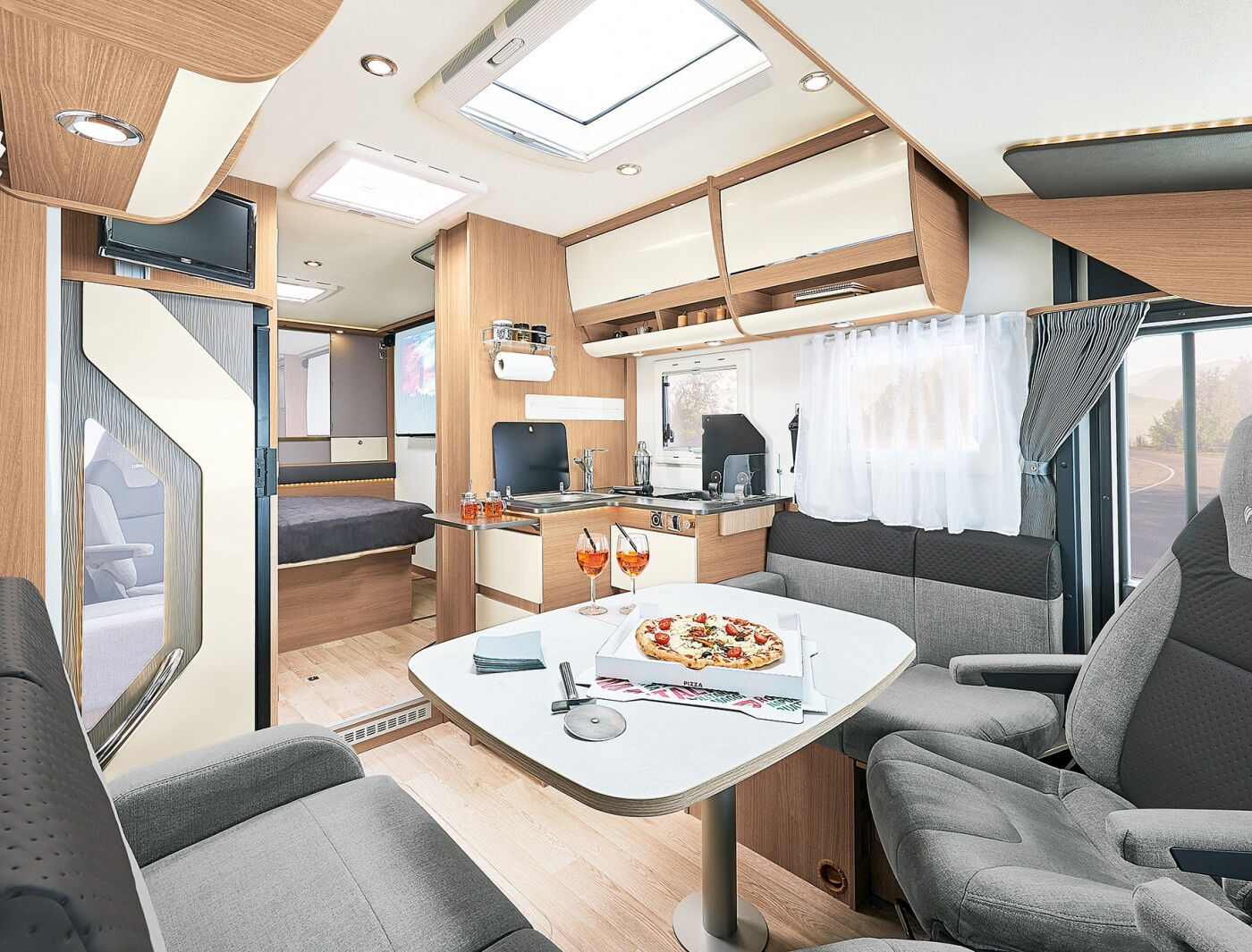 RC 740 : Dès l’entrée, son salon avec banquettes face à face crée un espace de vie spacieux et confortable pour 4 personnes. Son astucieuse table portefeuille de série permettra une circulation facilitée de l’espace salon à l’espace cabine. Les banquettes salon sont désormais équipées d’accoudoirs qui serviront également de repose-tête lors de la transformation des places face route, entièrement retravaillée pour ce nouveau millésime.