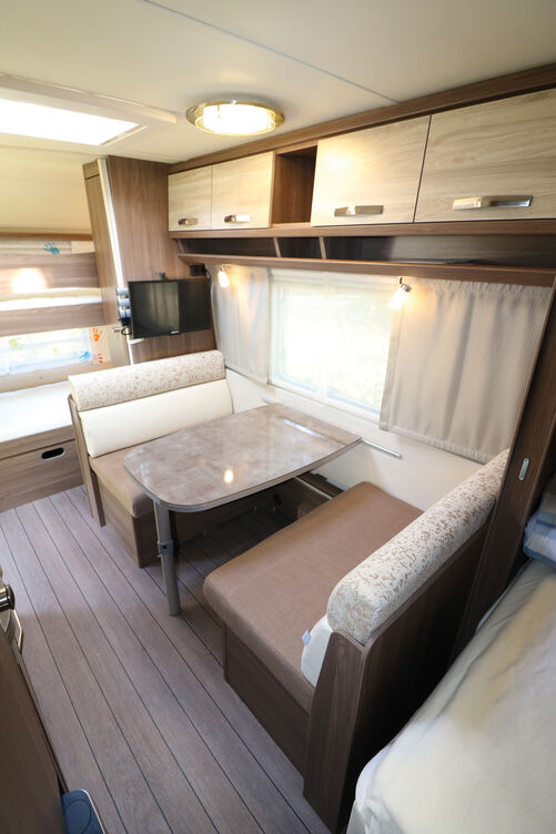 Das zweifarbige Möbeldekor sorgt zusammen mit den hochglänzenden Arbeits- und Tischflächen für ein modernes Wohnambiente.