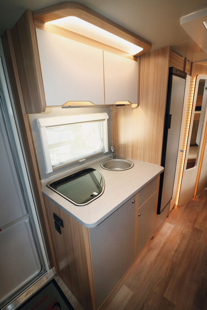 Die kompakte Küche bietet genug Staumöglichkeiten sowie einen grossen Kühlschrank.