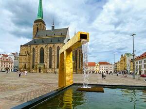 Les trois fontaines dorées modernes de la place Pilsener créent un contraste saisissant avec les bâtiments historiques.