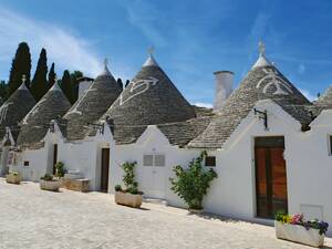 Des symboles de protection sur les toits en forme de cône couleur pierre naturelle des trulli d’Alberobello.