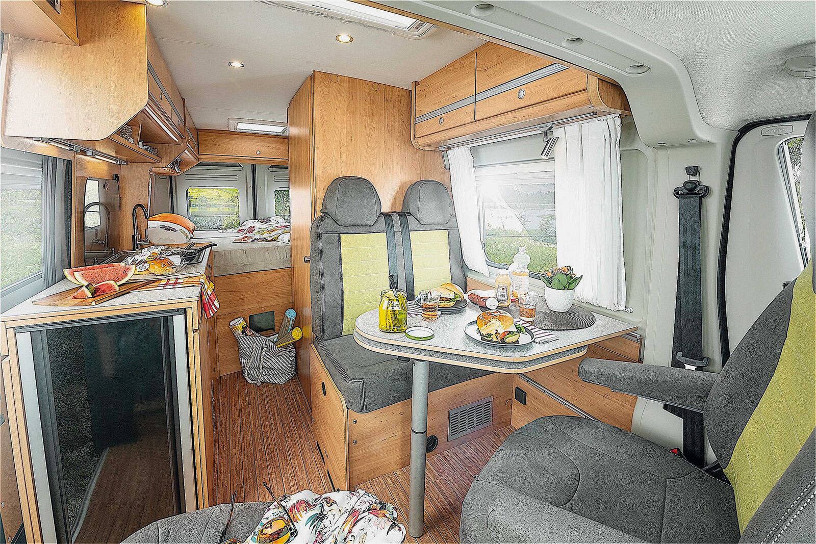 Blick über die Sitzgruppe, an Küche und Bad vorbei zum Heckdoppelbett.