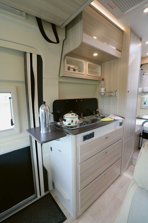 Die nach hinten versetzte Küche überzeugt mit kompletter Ausstattung, zusätzlicher Abstellfläche und adretter Optik.