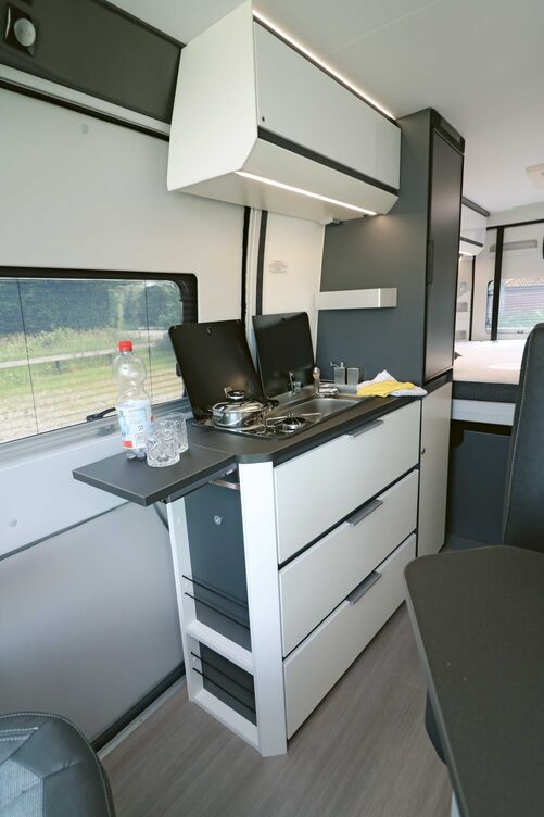 Die optisch ansprechende Küche im Kompaktformat bietet alles Notwendige und glänzt mit sicher schliessenden Beschlägen.