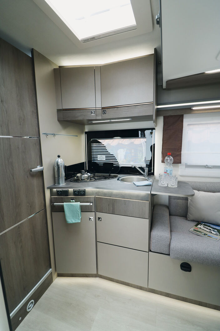 Die Küche in leichter Winkelform überzeugt mit kompletter Ausstattung und zahlreichen Beleuchtungselementen.