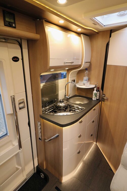 Die schicke Küche mit den hell glänzenden Fronten und der vielseitigen Beleuchtung überzeugt mit ihrer funktionalen Ausstattung.