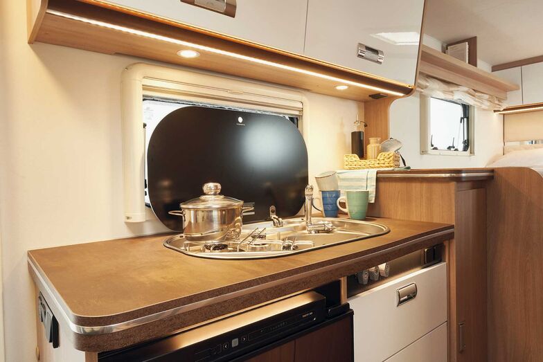 Küchenblock mit Spüle, Dreiflammenkocher und Arbeitsfläche.