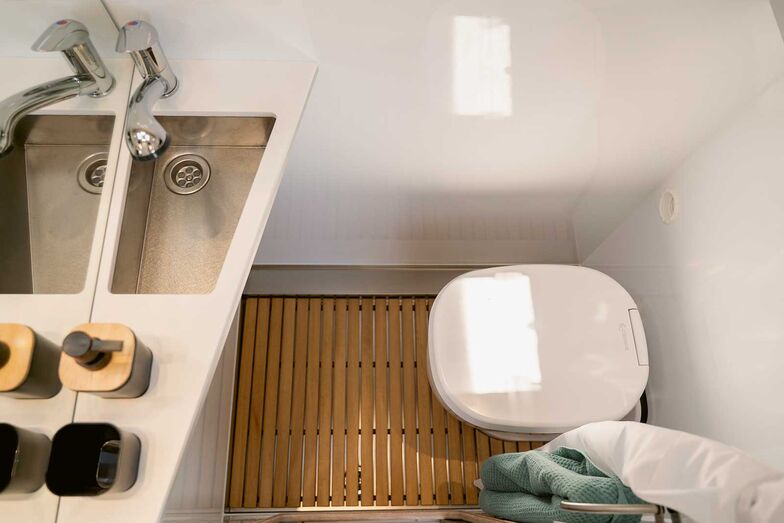 En face du bloc-cuisine : salle de bains compacte avec W.C. Clesana.