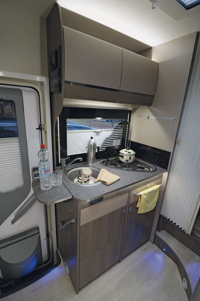 Compacte et fonctionnelle, la cuisine offre suffisamment d’espaces de rangement et des éléments d’éclairage divers.